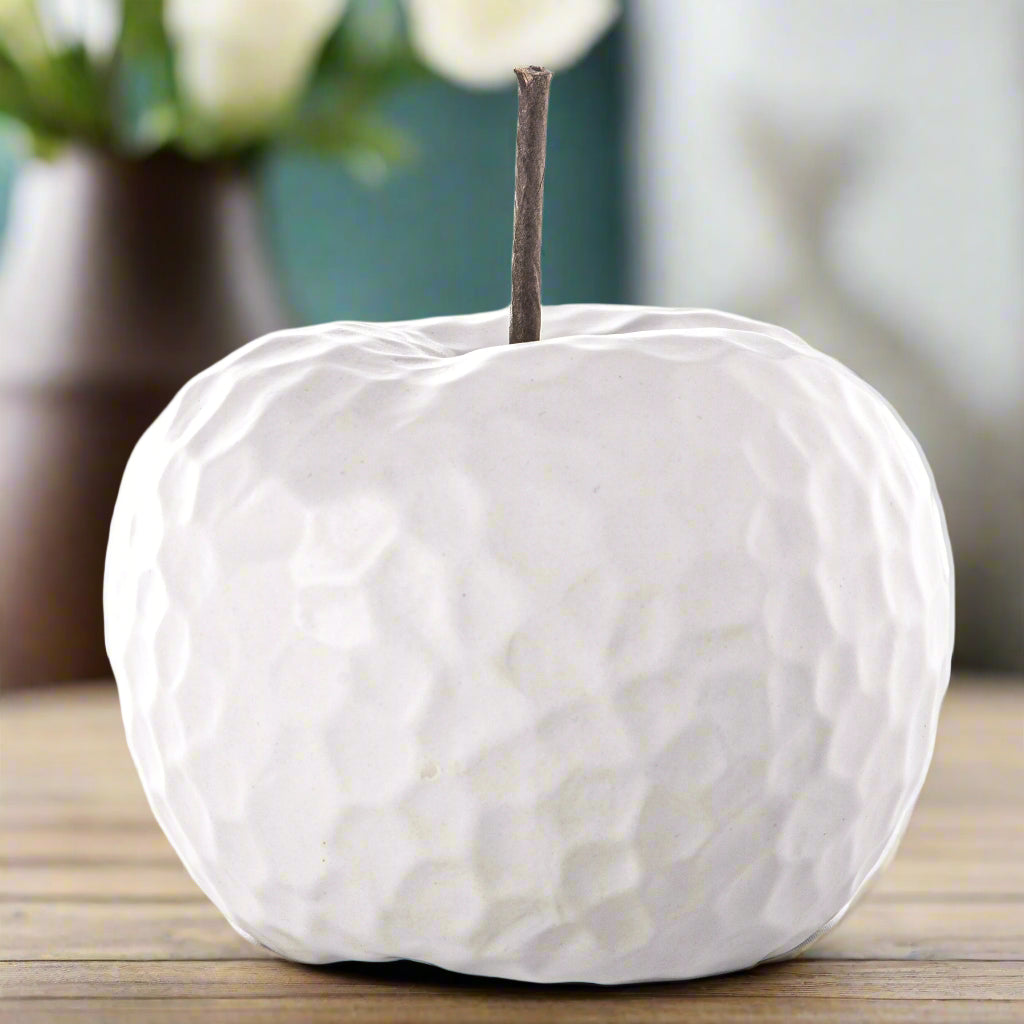 A ceramic apple figurine with a matte silver finish and a hammered design texture, featuring a stem.