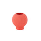 A matte white ceramic round vase with an embossed column and stripe design on the base.