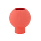 A matte white ceramic round vase with an embossed column and stripe design on the base.
