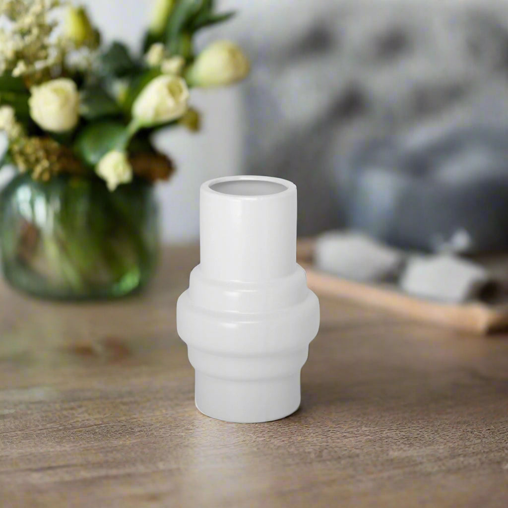 A white ceramic vase with a matte finish.