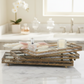 Three stacked rectangular decorative trays with mirrored surfaces and ornate gold-toned metal frames, styled with a glass perfume bottle, pampas grass, and a candle on a white background.
