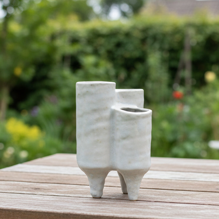 Two ceramic vases with a distressed finish in ivory color, featuring a wide top opening and a banded tapered bottom.
