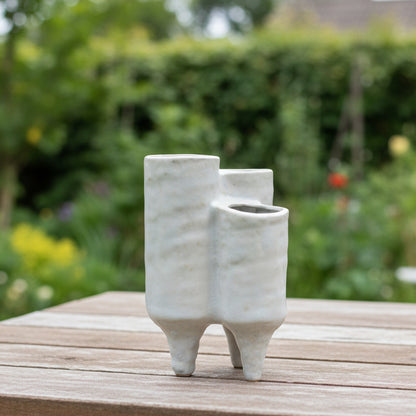 Two ceramic vases with a distressed finish in ivory color, featuring a wide top opening and a banded tapered bottom.