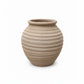 Beige ceramic vase with ribbed texture on a white background