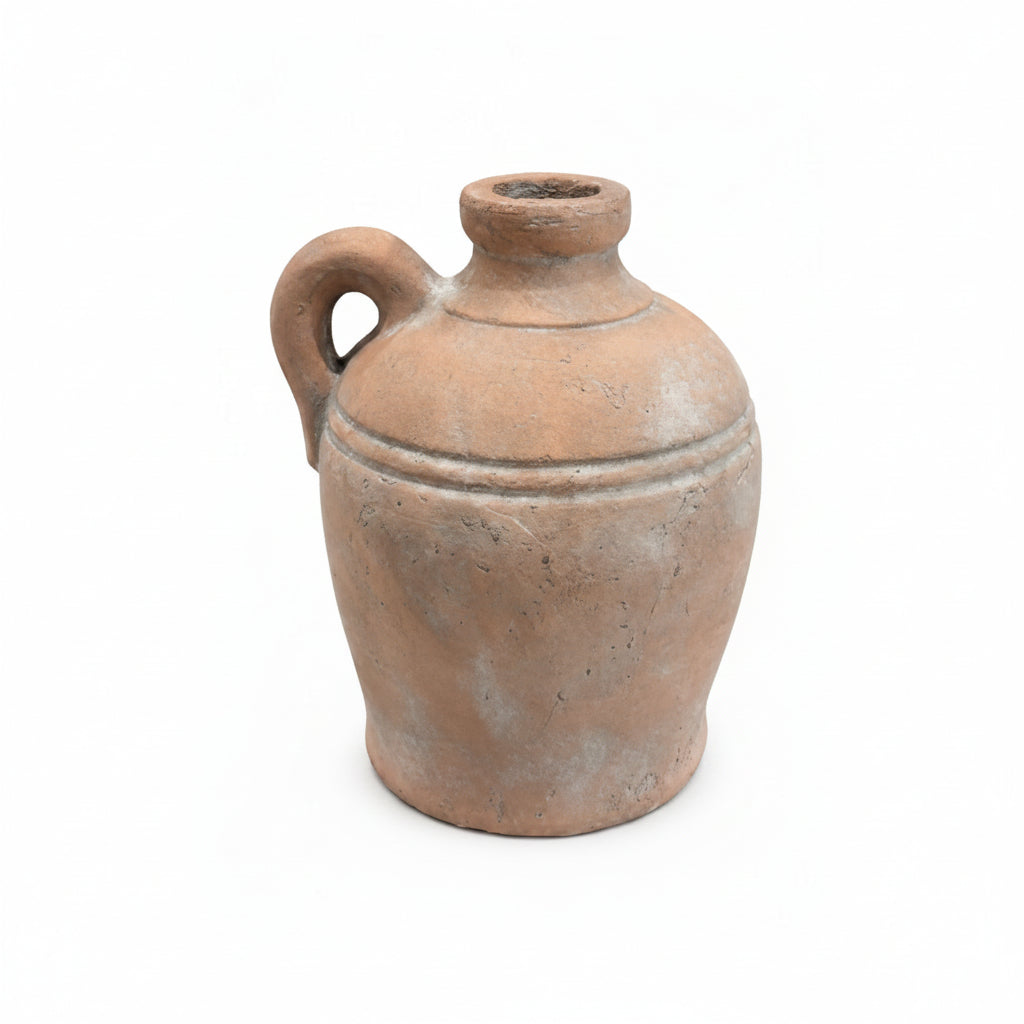 A rustic terracotta clay jug with a single loop handle and a short neck, shown on a plain white background.