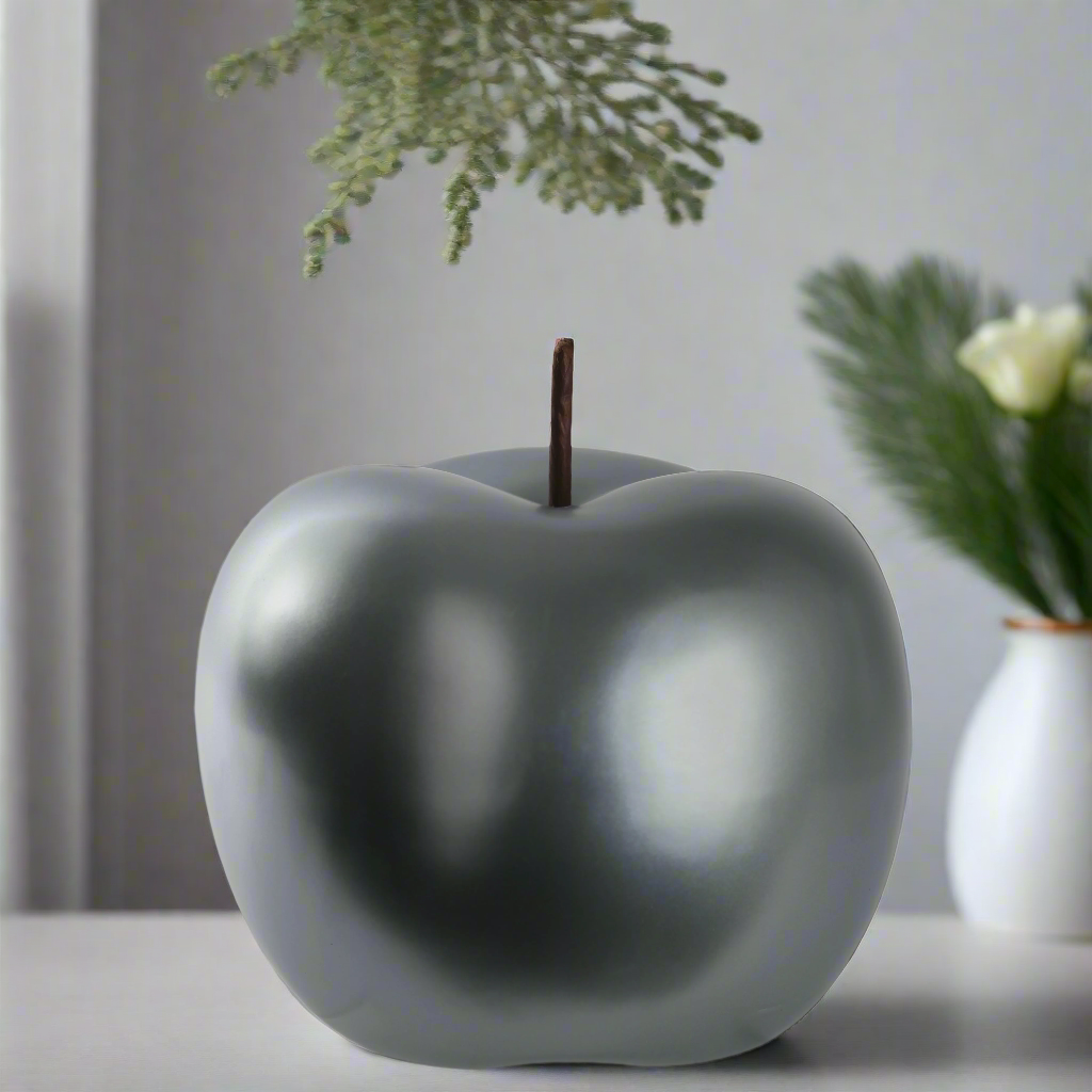 Gray ceramic apple-shaped object on a surface with a blurred background