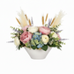 Floral arrangement with pink, white, and blue flowers in a white vase on a white background