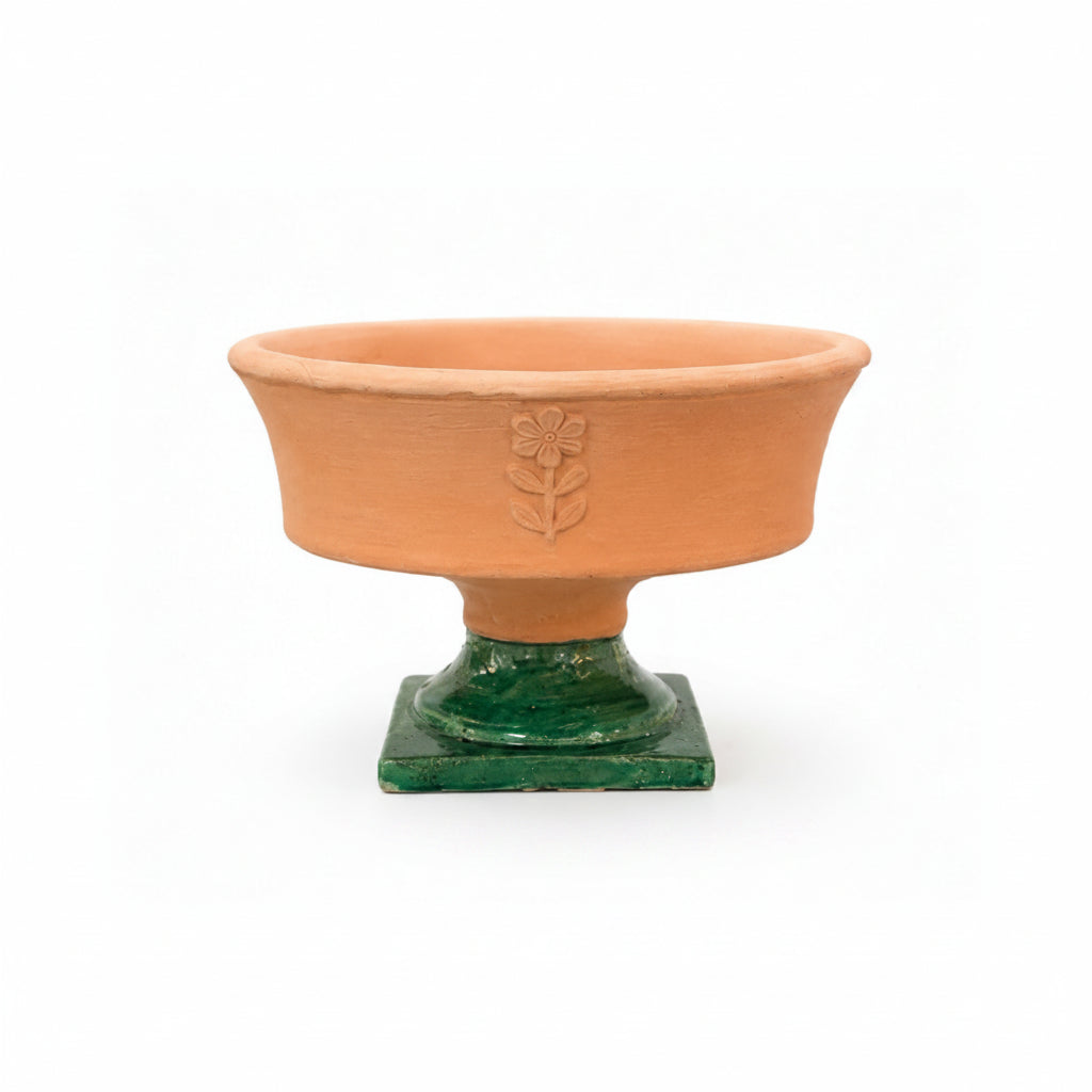 Terracotta bowl with green base on a white background