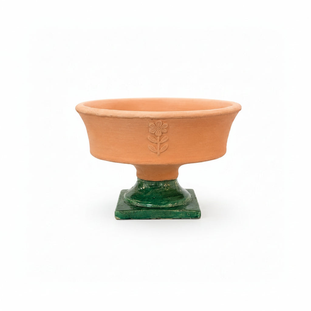 Terracotta pedestal bowl with green base on a white background