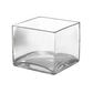 Clear glass cube on a white surface with a blurred background